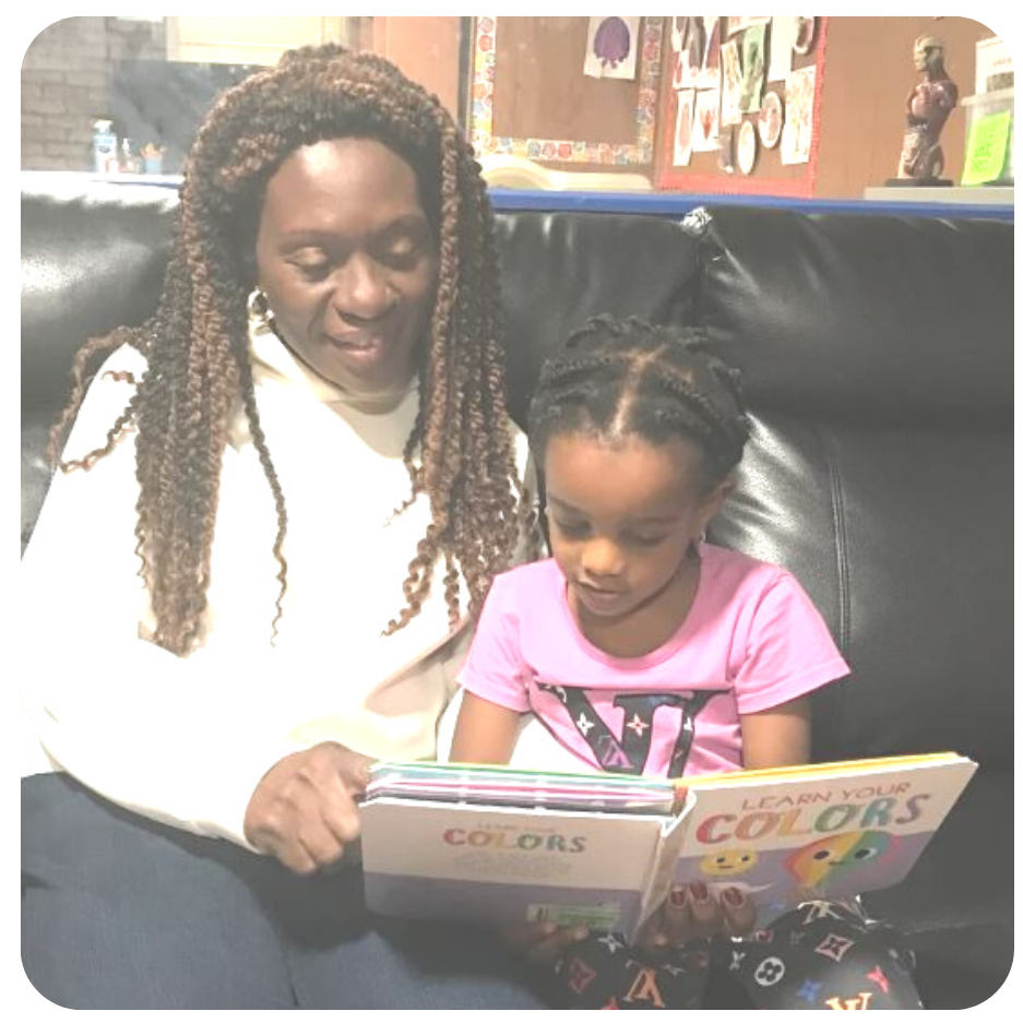 Esther reading with girl on couch in frame