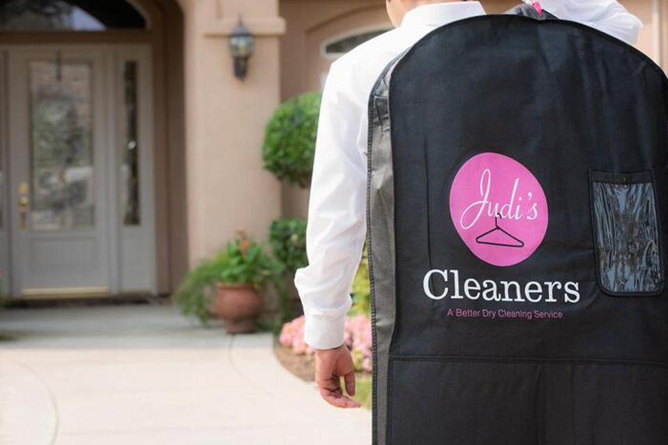 Judis cleaners employee delivering suit