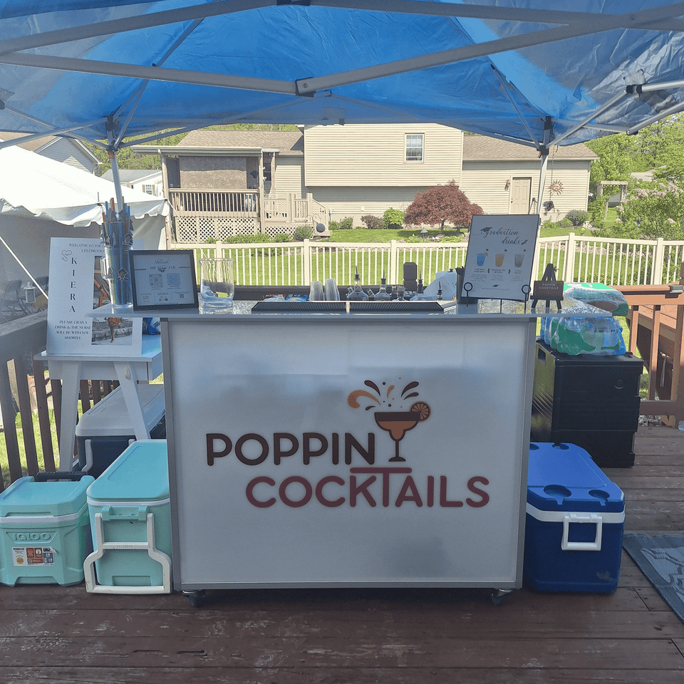 Poppin Cocktails 4ft light-up portable bar set up for beverage service at an outdoor graduation celebration.