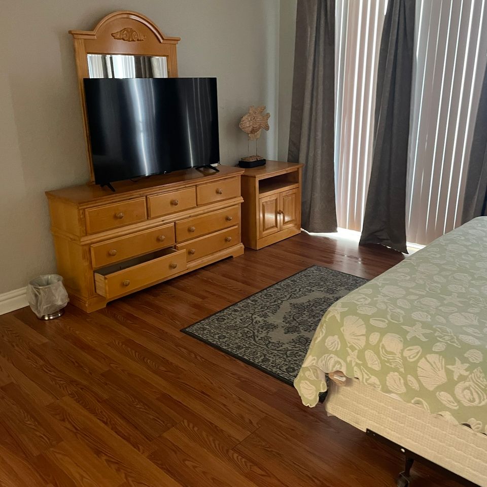 Bedroom with wood dresser and clean hardwood floor after house cleaning service in Virginia Beach VA