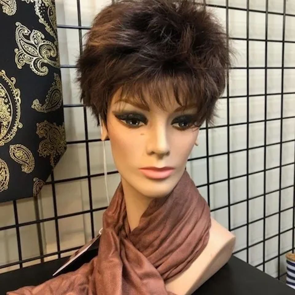 Short brunette layered wig displayed on a mannequin, featuring soft volume, textured layers, and a natural-looking finish.