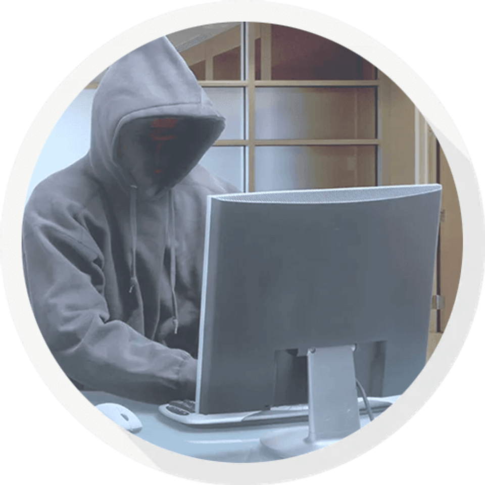 Hooded figure on computer