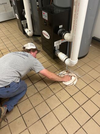 Alec plumber helper working leakiong heater