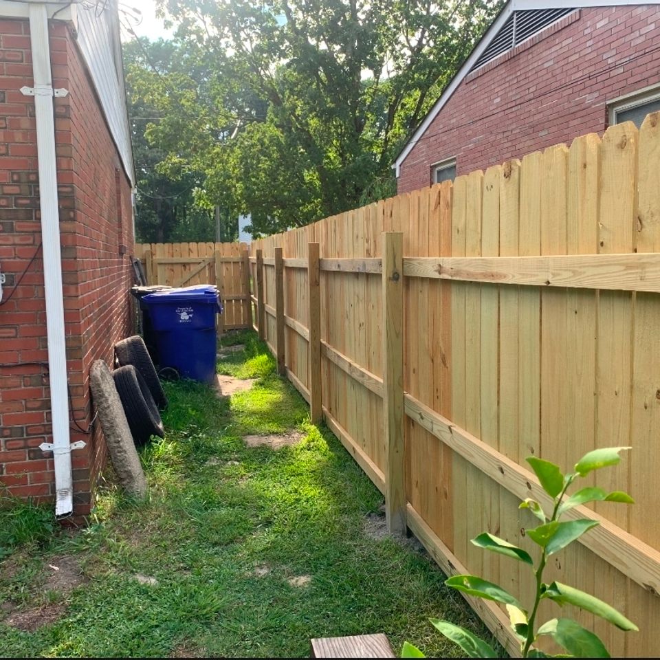 Wood dog-ear privacy fence installation along brick home side yard in Virginia Beach VA