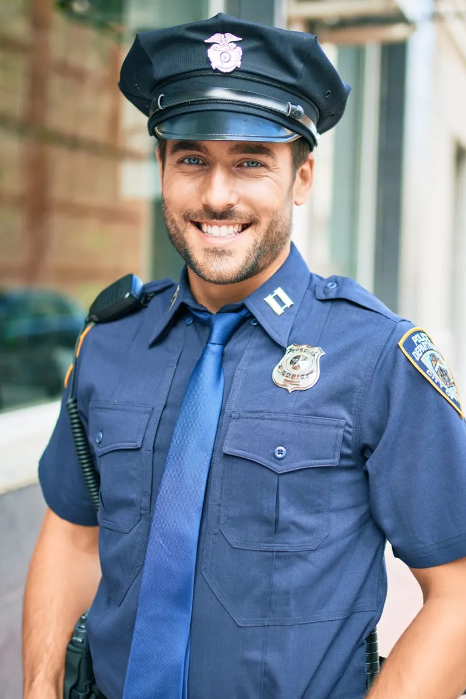 policeman wearing police uniform smiling happy Standing with smile on face at town street
