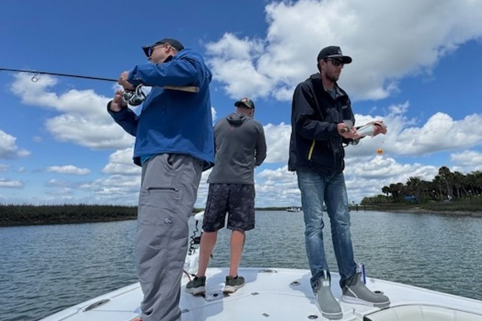 Three men fishing from front deck of a charter boat