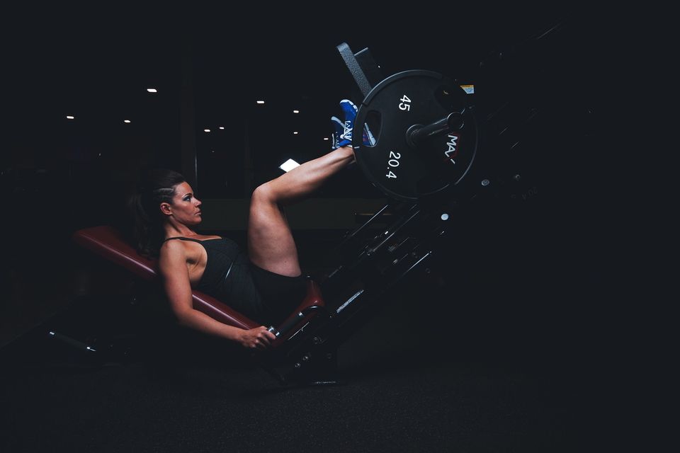 Woman Exercising On A Leg Machine 