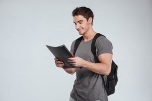 Smiling male student with folders and backpack over white background sbi 302891580