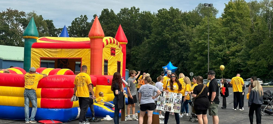 Children and families gathered near an inflatable bounce house during the DSAV Buddy Walk event.