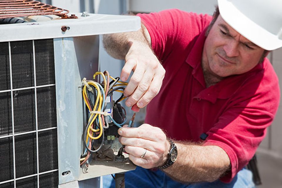 hvac tech working on outside condensing unit