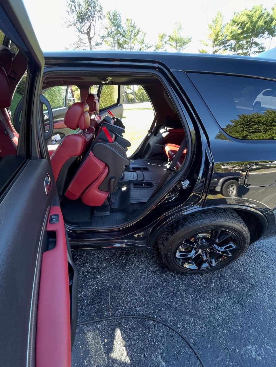 Black Dodge Durango with clean red leather seats and all-weather mats after interior cleaning in Wilmington