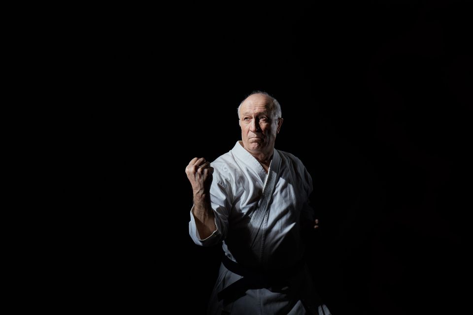 An old man practicing karate to keep in shape and active