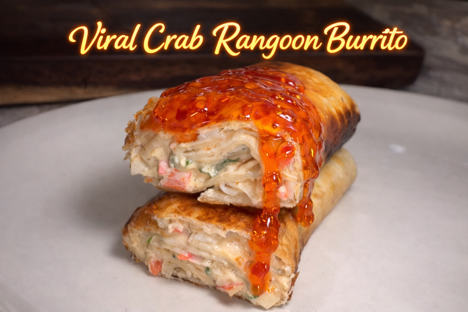 Crispy crab rangoon burrito sliced in half and served with sweet chili sauce on the side