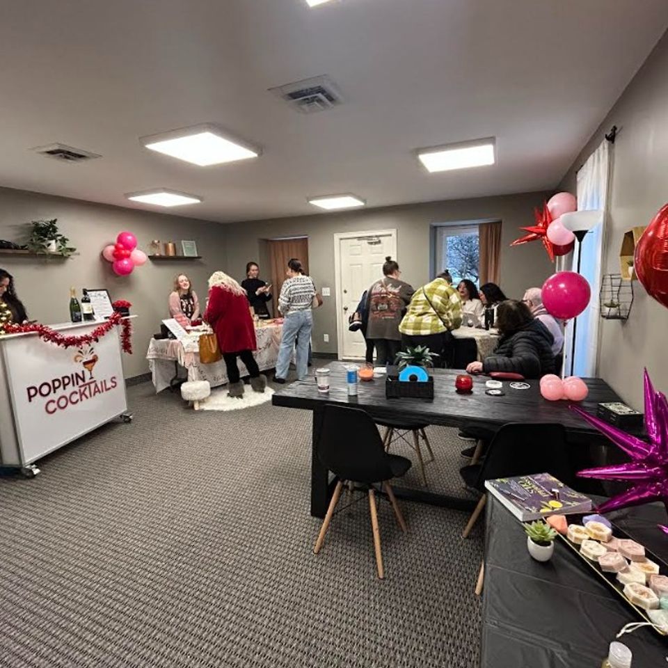 : Indoor Galentine’s Sip & Shop event with vendors, guests, and full bar setup