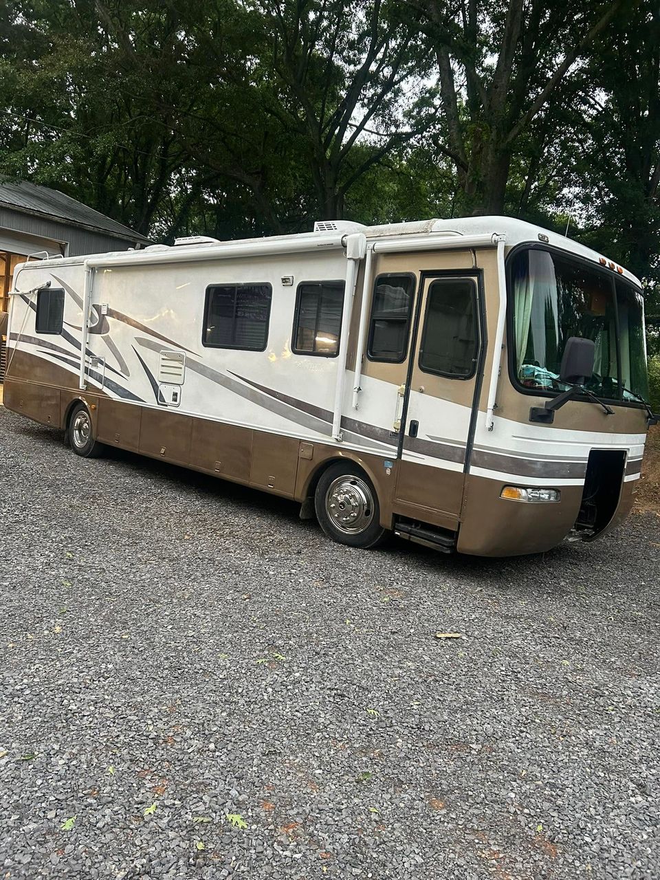 Tan and white Class A motorhome parked at truck repair shop in Arab Alabama