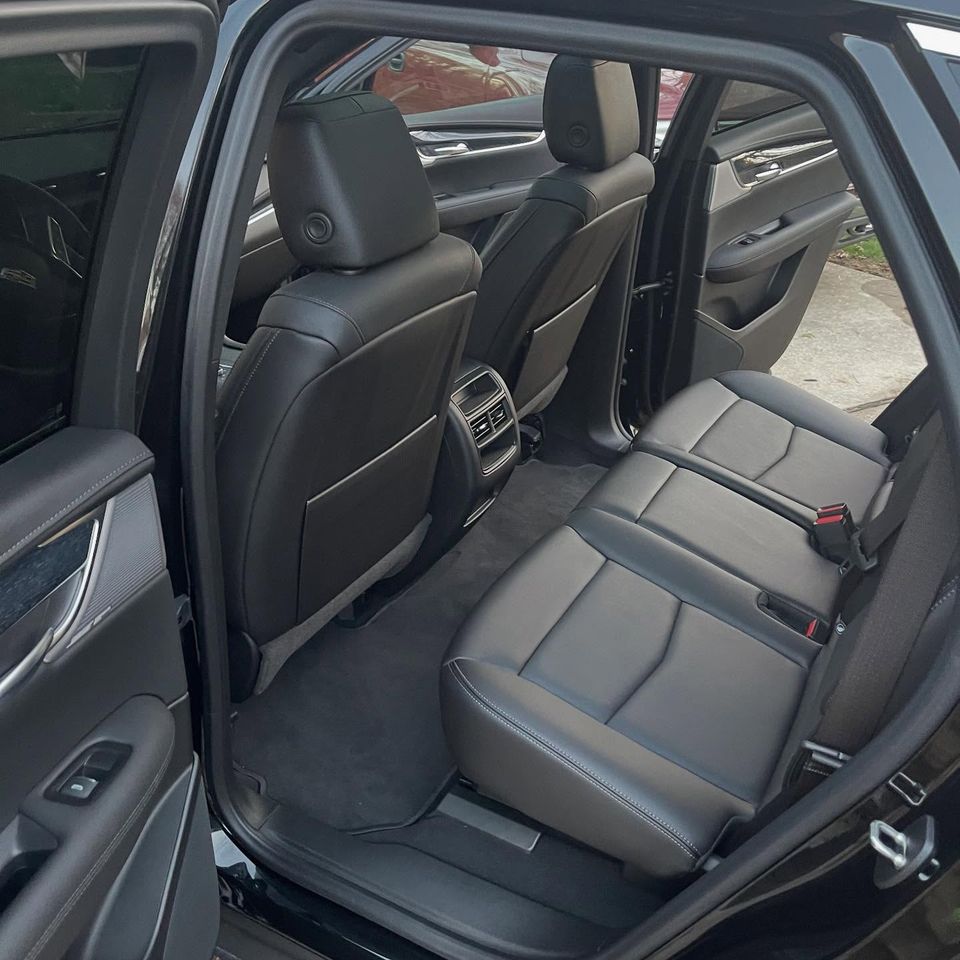 Spotless black leather rear seats and carpets after a full interior cleaning on a Cadillac in Wilmington Delaware