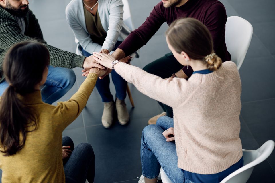 Participants group therapy gathering hands unity during session medical center (1)