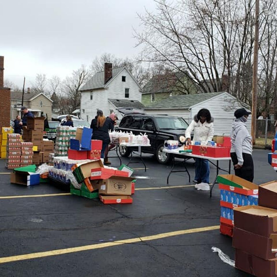 Volunteers organizing and distributing supplies in the parking lot during a community outreach event hosted by Grace Evangelistic Temple Church.