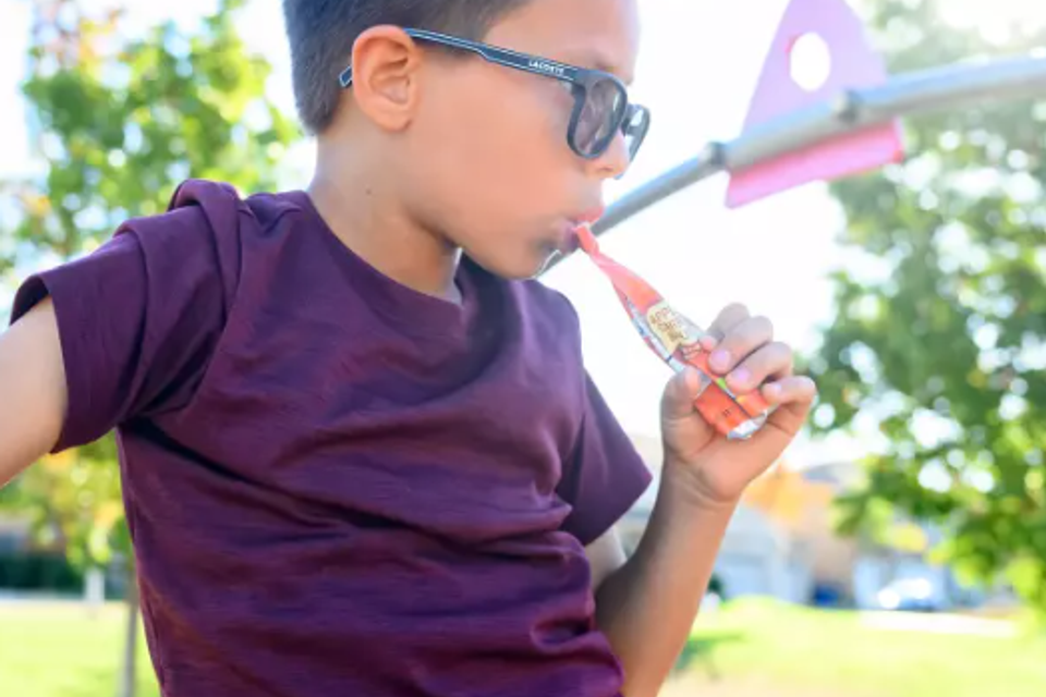 Kid eating yogurt from pouch