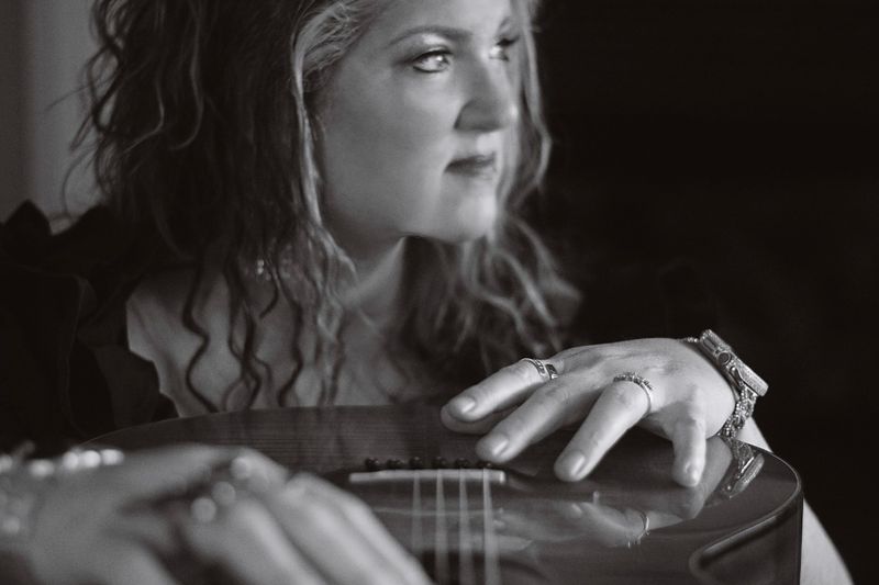 Black-and-white portrait of Stacy Wynette with an acoustic guitar