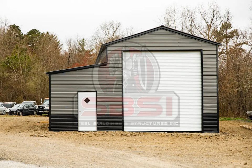 Gray and black steel building with tall roll up door and entry door with SBSI watermark representing steel buildings in Alabama