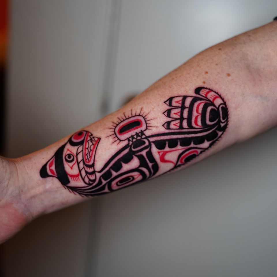 Image of a Mayan or Aztec dog lying down in red and black colored ink
