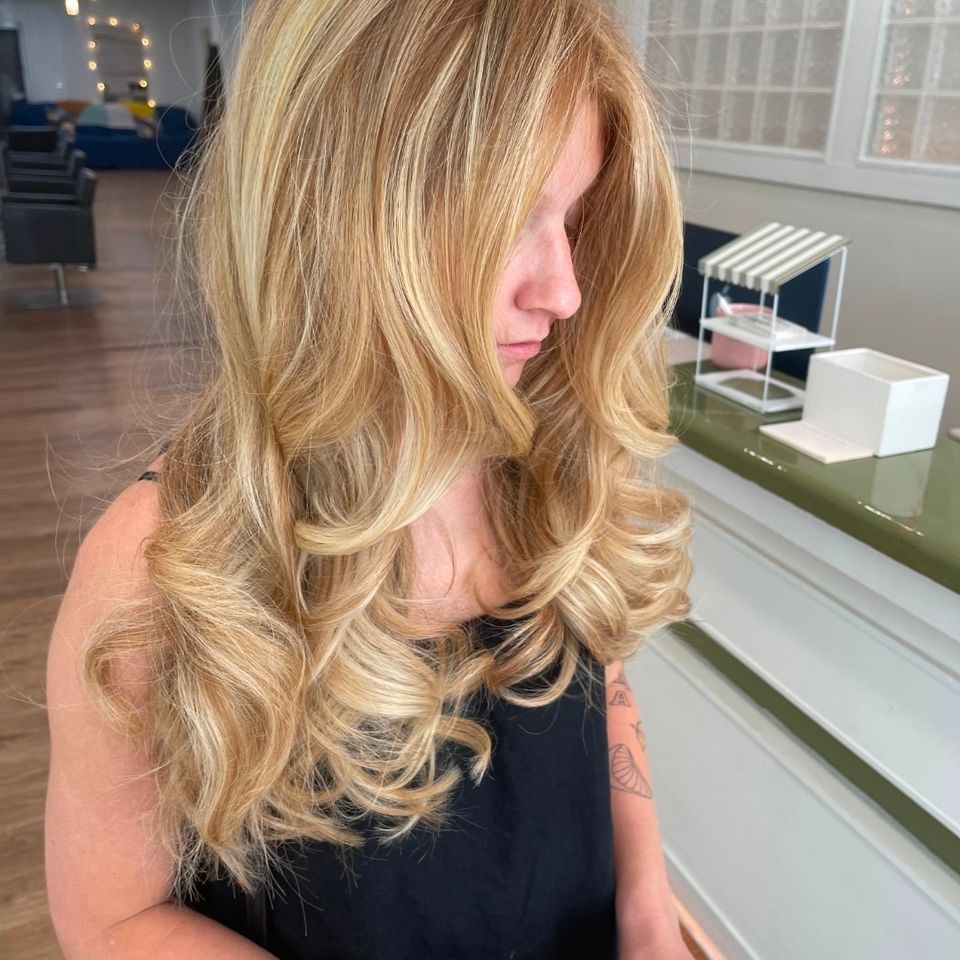 Long golden blonde hair with bouncy curls after color and styling in Columbiana AL