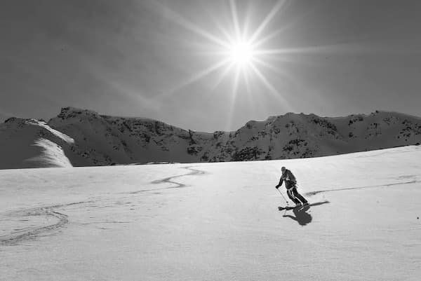 Black and white skier with a beautiful sun shining 