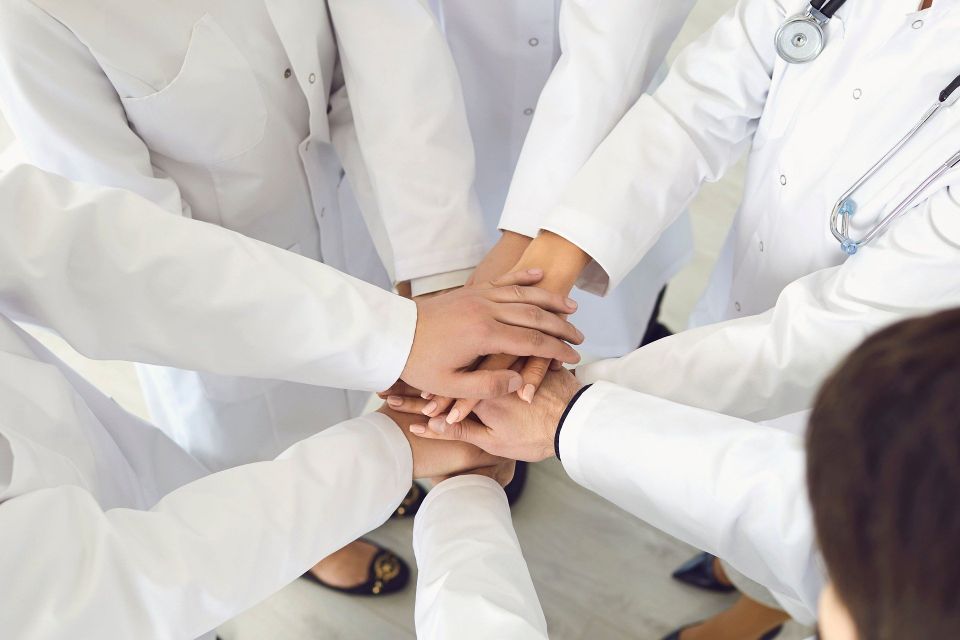 Healthcare professionals huddling and working together to handle high volume of patients 