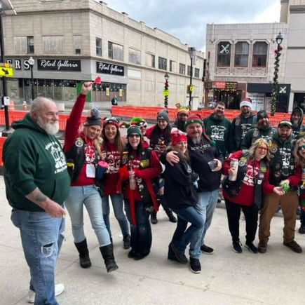 Group of holiday-themed event participants posing together outdoors in downtown Youngstown during a festive gathering.