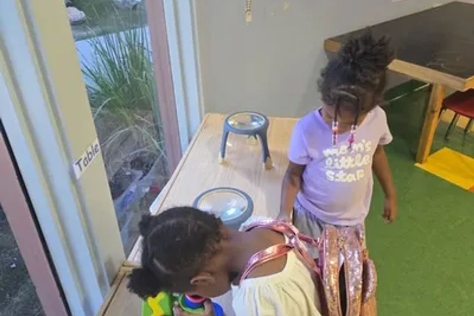 Two children are playing in a room with toys