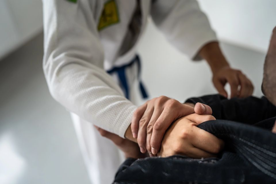 Close-up of hands gripping a black gi during Brazilian Jiu Jitsu sparring