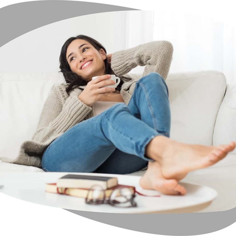 Woman relaxing on a couch with a warm mug after Myers Cocktail IV therapy in Palm Beach County