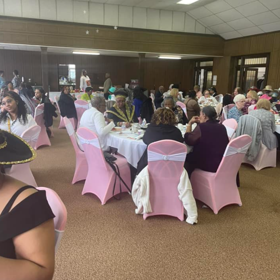 Attendees seated at decorated tables during a fellowship gathering at Grace Evangelistic Temple Church, sharing a meal and enjoying community fellowship.