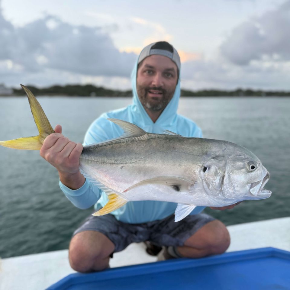 Angler holding a large fish while seated on a boat