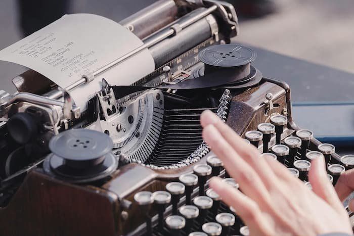Person typing on old-timey typewriter 