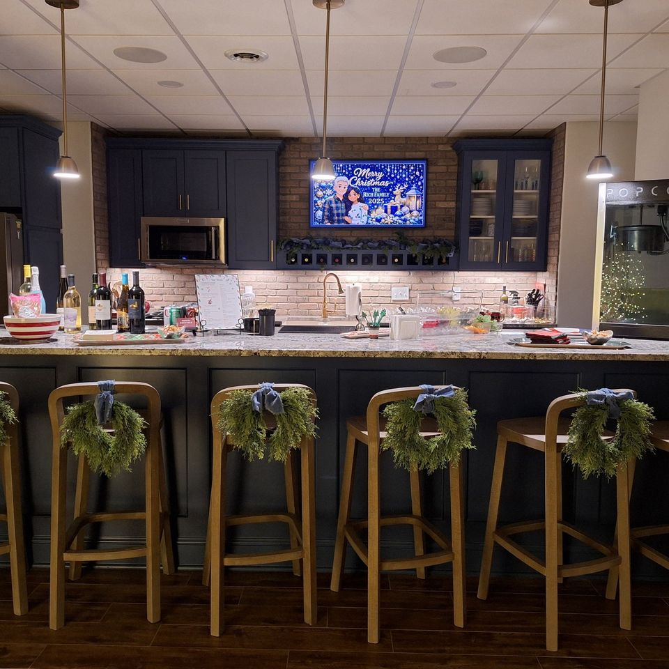 Decorated bar with stools, wreaths, and drink setup for a holiday party