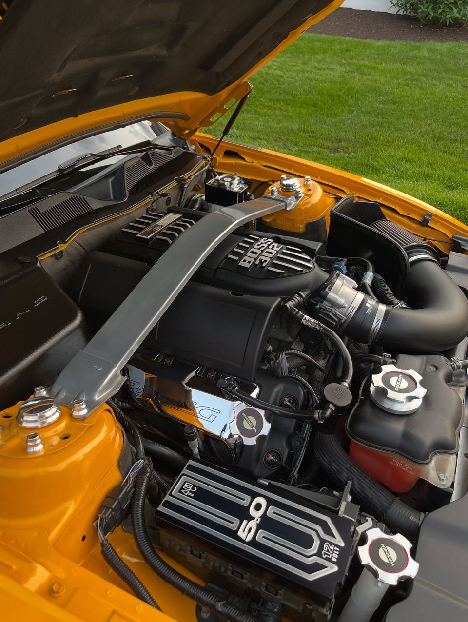 Ford Mustang Boss 302 engine bay with polished caps and strut tower brace after engine bay detailing