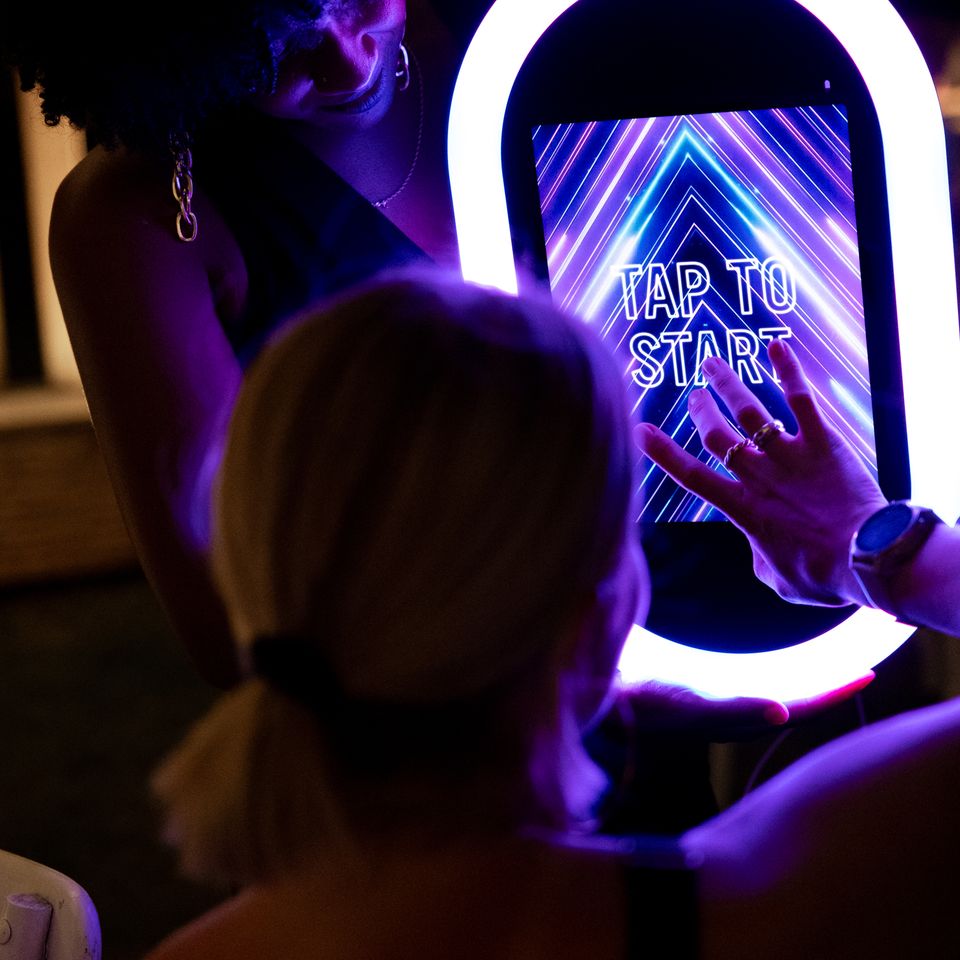 Guest tapping the screen of a modern photo booth.