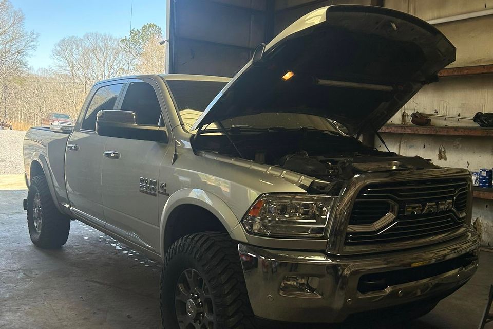 White Ram 2500 diesel truck with hood open inside truck repair shop in Arab Alabama