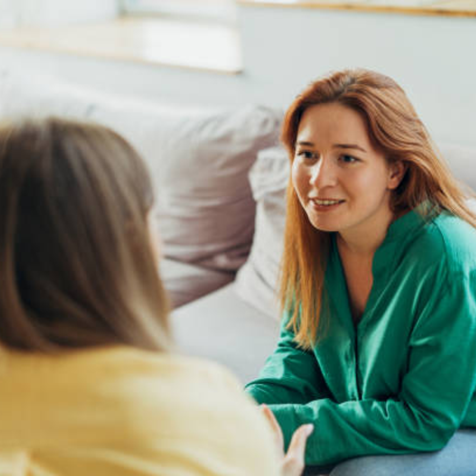 Woman offering emotional support to another woman during an at-home counseling moment