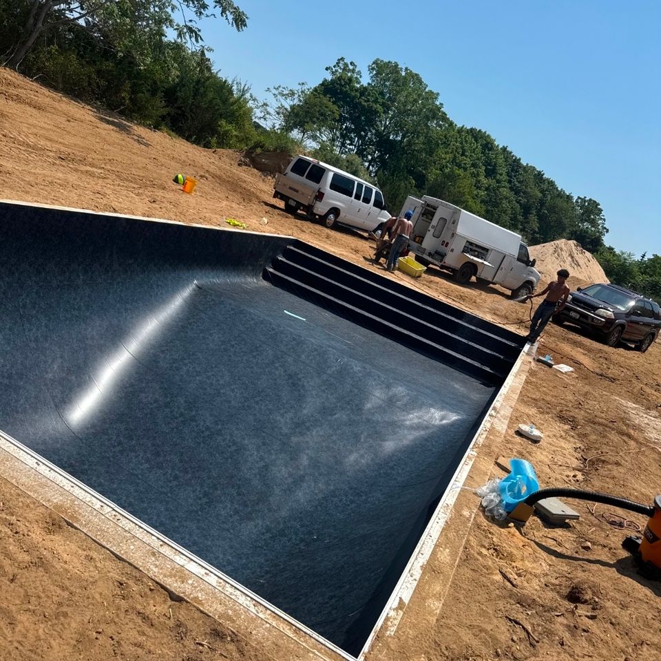 New black pool liner installed in an inground pool shell during construction on Long Island