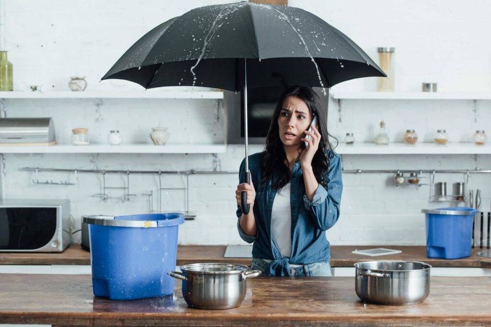 Upset woman standing under umbrella in kitchen and 2022 02 03 10 42 32 utc min scaled 1 1024x684