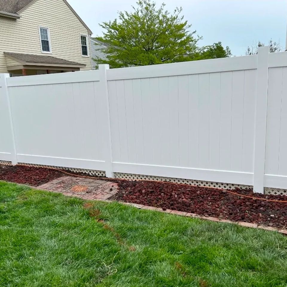 White vinyl privacy fence with lattice bottom installed along landscaped yard in Virginia Beach VA 