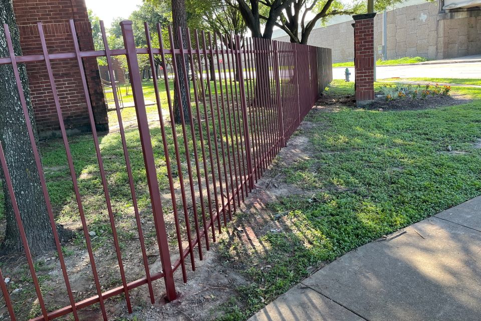 Completed iron fence replacement project with newly installed steel fencing in Houston.
