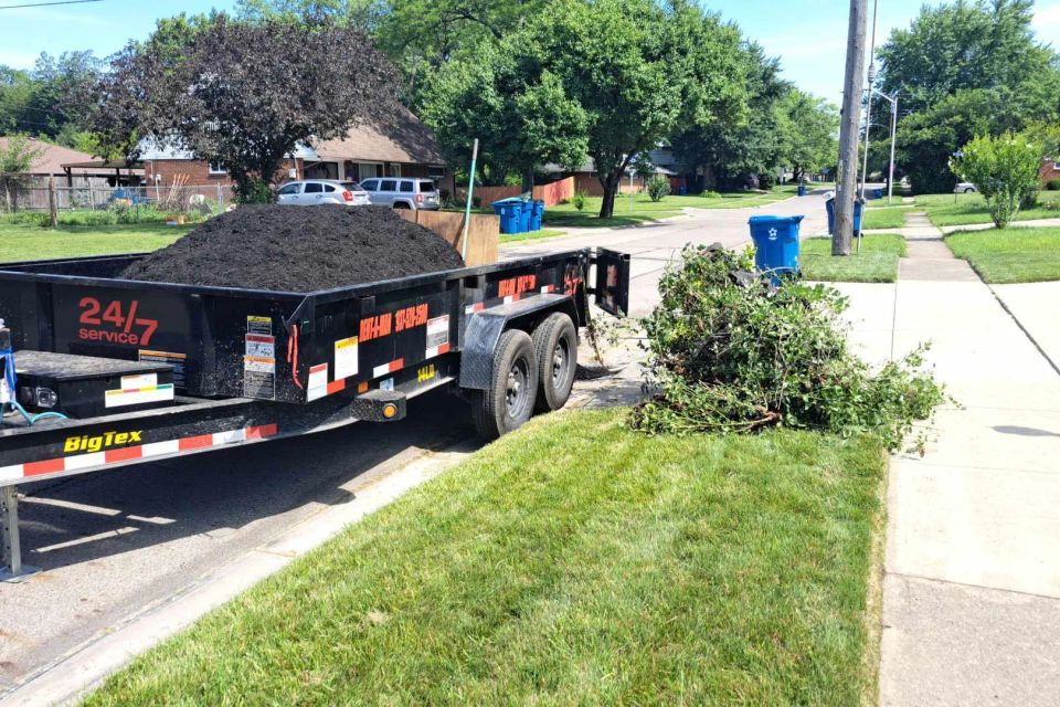 Trailer loaded with premium black mulch parked in a residential neighborhood before landscape installation.