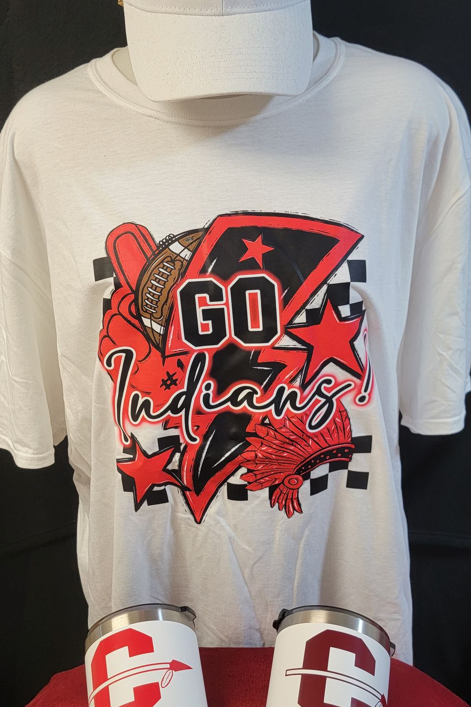 Example of Direct to Film (DTF) transfer - "Go Indians" Cleveland ISD logo on a white t-shirt, embroidered cap, and screen-printed tumblers.