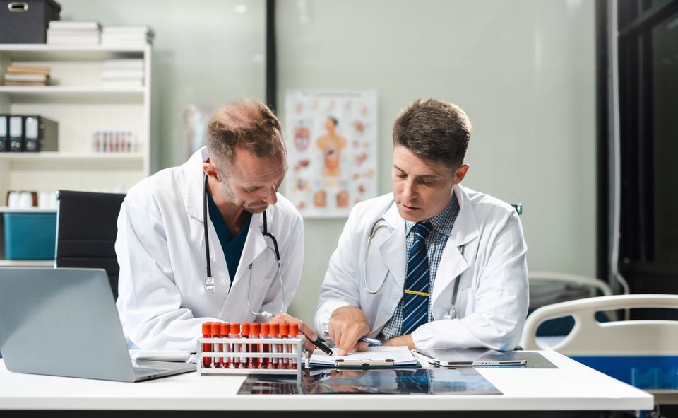 Clinicians reviewing blood work to rule out secondary hypertension causes like kidney disease thyroid disorders or sleep apnea