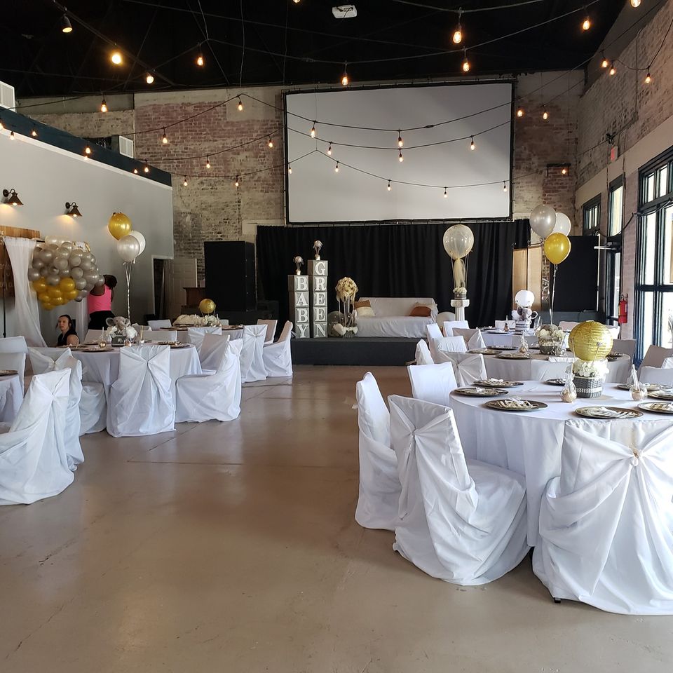 Setup for one of our wedding receptions with white table drapes and gold and white balloons.