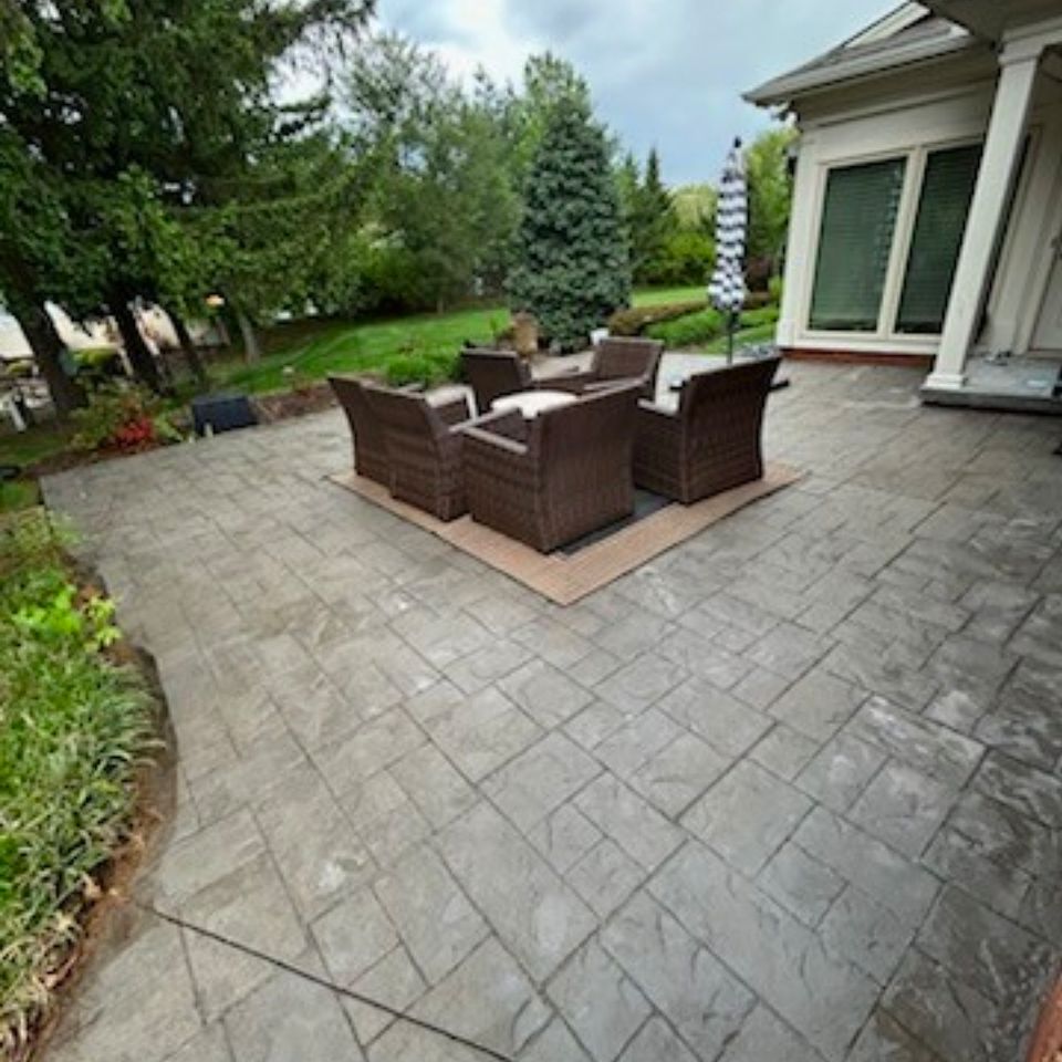 Stamped concrete patio with wicker seating after pressure washing service in Harrisburg PA